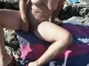 Frau steckt sich einen Dildo rein am Strand