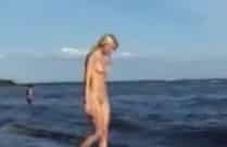 Süsse Blondine lässt sich nackt am Strand filmen