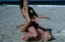 Frauen kämpfen am Strand miteinander