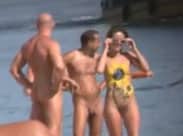 Nackte Frauen und Männer am Strand